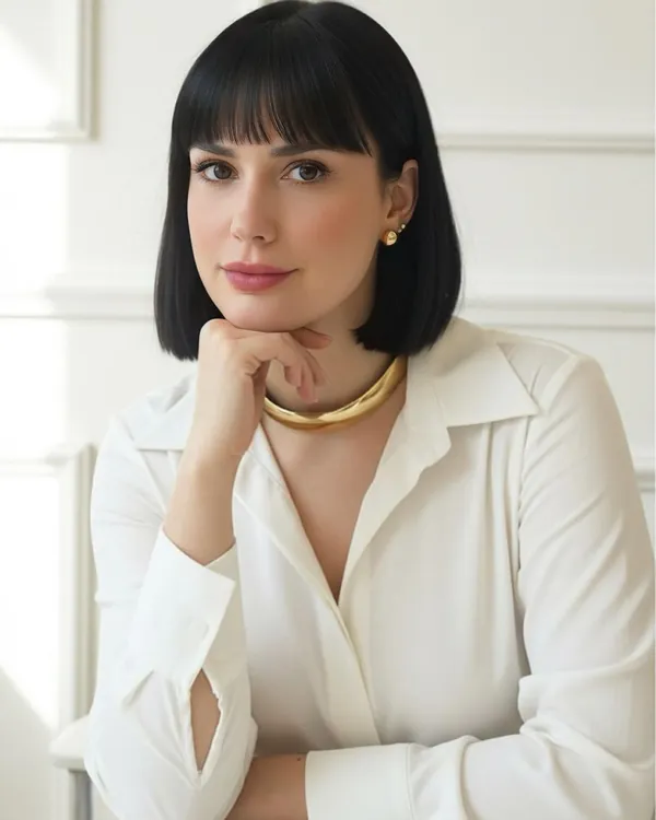 Raíni Crepaldi sorrindo, de blazer branco